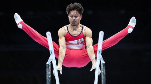 Jake Jarman performs on the parallel bars