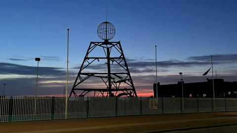 Silhouette of log flume's main tower at sunrise