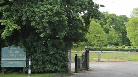 The entrance to Upton Country Park with the gates open and the welcome sign beside.
