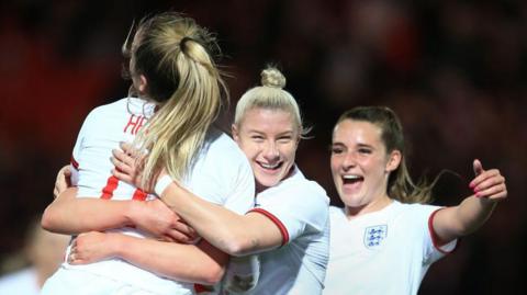 Bethany England and Ella Toone celebrate with Lauren Hemp