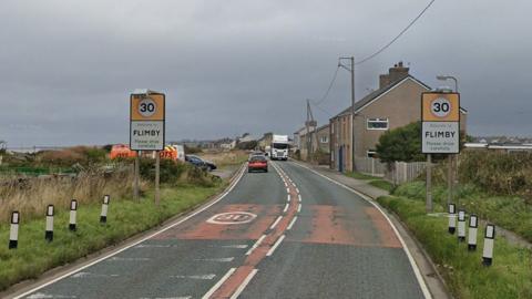 The road entering Flimby with signs warning of a 30mph speed limit.