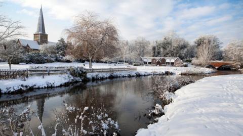 Godalming, near Guildford, Surrey in Southern England covered in snow. Picture shows the River Wey, St Peter's Church and Philips Memorial