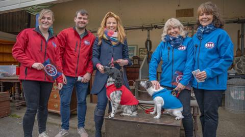 Bargain hunt teams with two dogs smiling for a photo