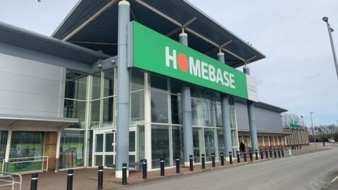 A former Homebase store with a grey frontage and road in front of it