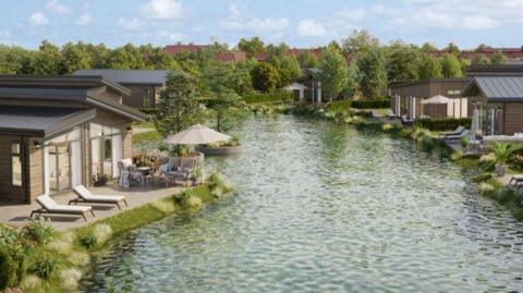 Wooden holiday lodges set around a pond lined with trees.