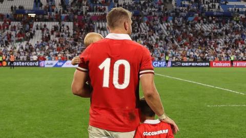 Dan Biggar with his children showing the 10 shirt