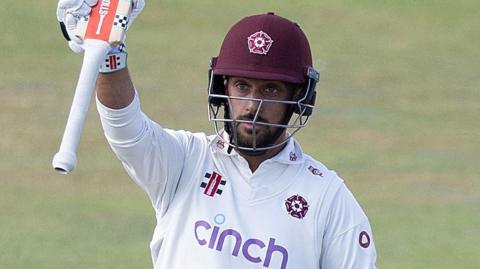 Saif Zaib raises his bat to the crowd