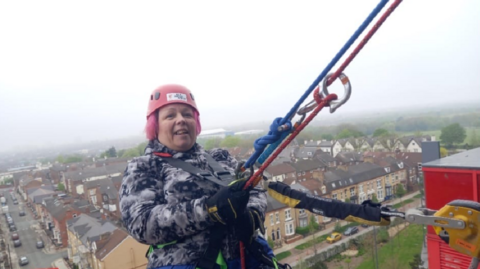 Trish Brookes abseiling down Anfield