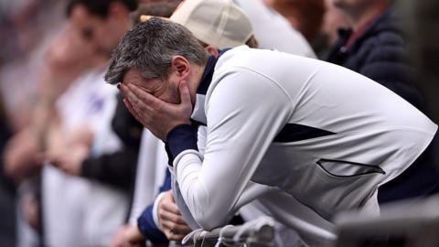 Football fan leans on chairs with head in hands