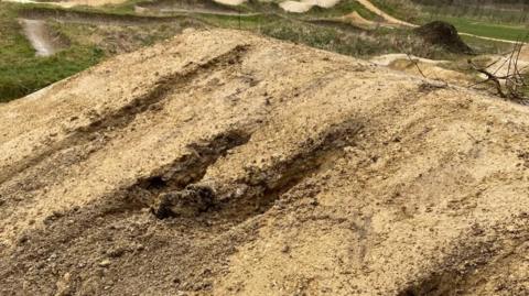 Three big holes in the ground of a BMX track.