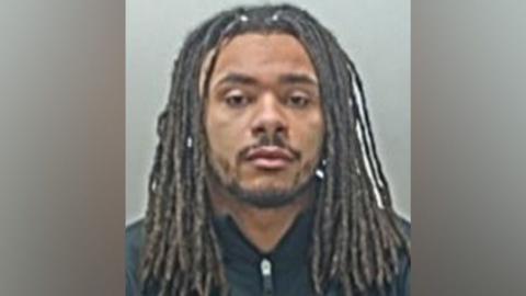 Andrew Phillips is staring directly at the camera and he has no expression on his face in his police mugshot. 