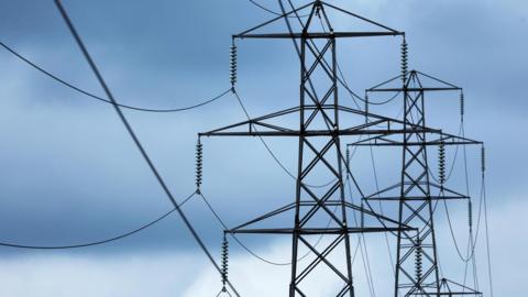 Grey metallic pylons with a stormy sky behind them.