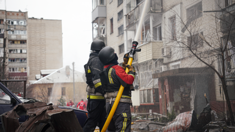 Firefighters extinguish a fire at damaged residential building in the city centre after Russian shelling on March 24, 2025 in Sumy, Ukraine.