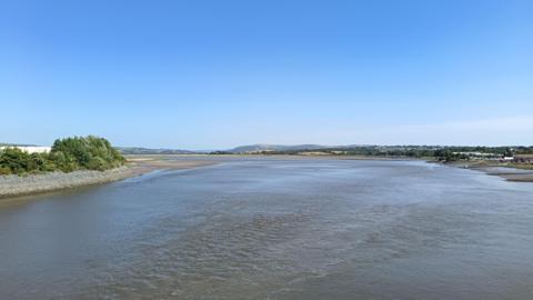 A large river surrounded by two banks, leading out to sea