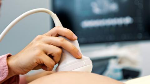 Young female doctor performing ultrasound on a pregnant woman