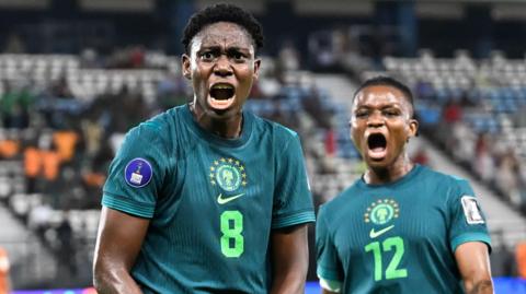 Asisat Oshoala and Uchenna Kanu celebrate a goal for Nigeria