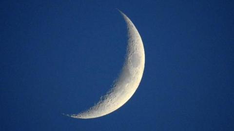 A small portion of the moon visible in the sky 