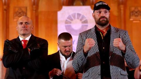 Oleksandr Usyk and Tyson Fury pose for pictures at a news conference