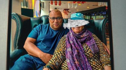 Pastry chief Graham Hornigold in a navy blue t-shirt sits with his mother Dionne Marie Hanna, wearing a baju kurung, purple scarf, teal hat, on a couch in a restaurant