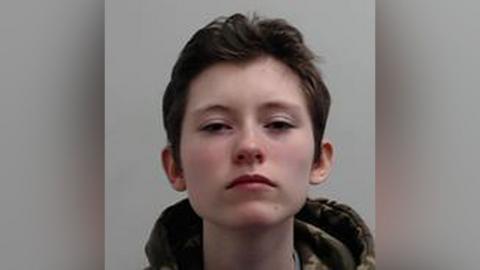 A mugshot of Felix Winter, who has dark hair and appears to be wearing a camouflage jacket with the hood down
