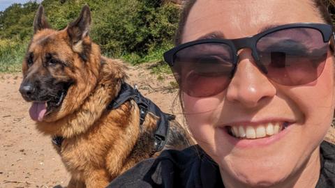 Pub manager Kayleigh Blake posing for a selfie with her German Sheppard dog Pullo. Kayleigh is wearing sunglasses and dog has it's tongue out on a sunny day. 