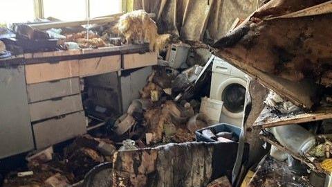 Empty home with rubbish piled up in a kitchen area