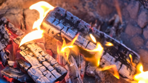 A small fire with yellow flames and white embers