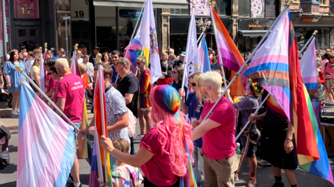 People with rainbow flags celebrating Notts Pride in Nottingham city centre on 25 July.