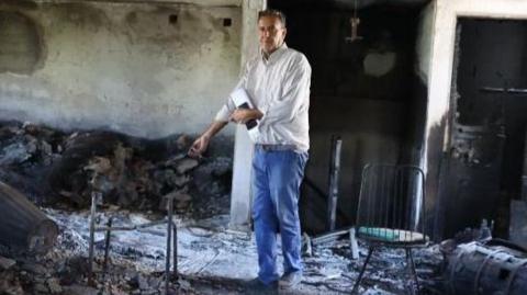 A man in a room holds a burnt item