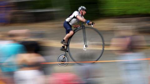 A penny farthing in a race