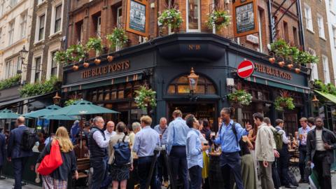 People standing and drinking outside The Blue Posts pub