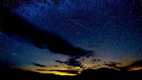 Dark clouds against a starry early morning sky