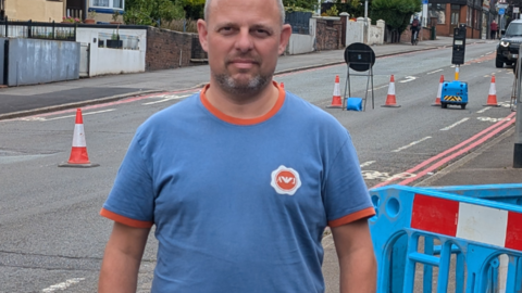 Resident David Broome stood by roadworks signs on City Road