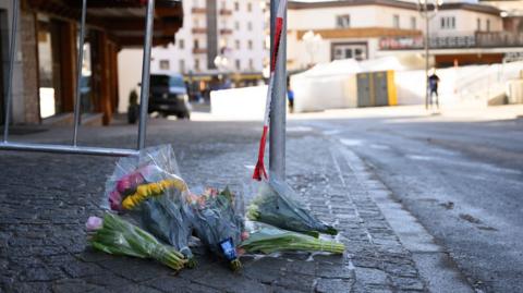 Flowers are laid on the street after a fire broke out overnight at Le Constellation bar on January 01, 2026 in Crans-Montana, Switzerland
