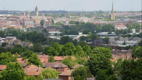 A view of Wakefield taken over the top of trees and houses 