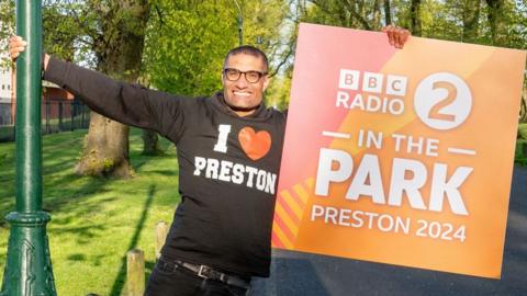 Richie Anderson holds a ˿ Radio 2 In The Park sign