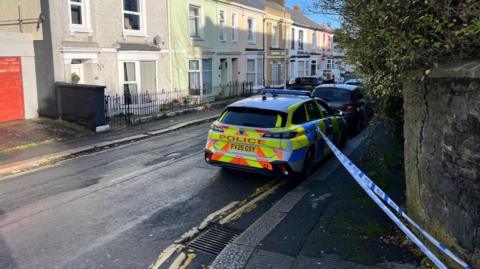 A picture of the cordon in place at the scene. It is blue and white tape. 