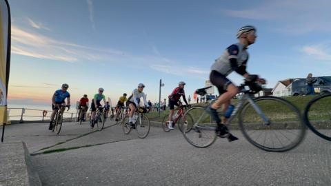 Cyclists riding by the coast.