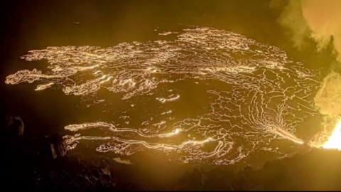 Glowing lava creates golden patterns as Kilauea erupts.