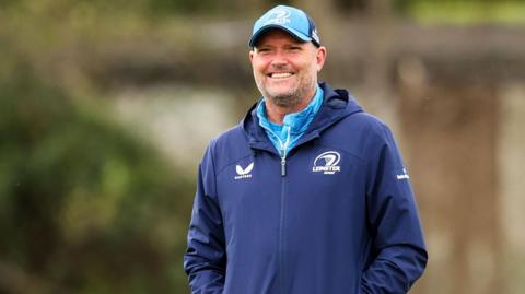 Jacques Nienaber smiling while wearing Leinster zip-up club jacket