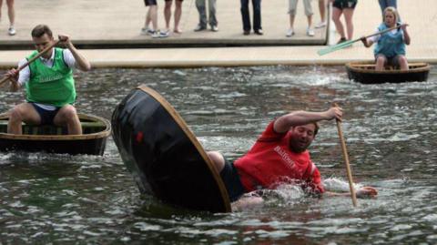 A competitor falls into the river as he takes part in what is claimed to be the first coracle relay race world championship