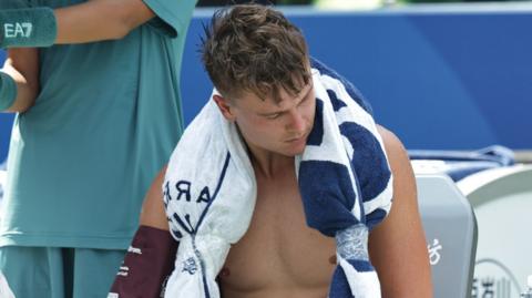 Holger Rune has his blood pressure taken as he sits with an ice towel over his shoulders at the Shanghai Masters