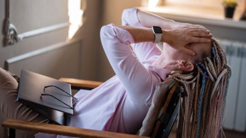 Woman puts head in hands in despair