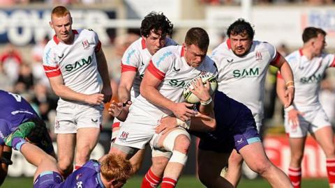 Zac Ward of Ulster is tackled as he runs through with the ball in his arm