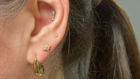 A women's ear with the lobe, seconds and inner ear pierced.