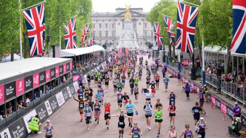 Runners make their way down The Mall to the London Marathon finish line