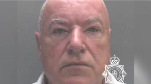 Custody image of Neil Foden, who has short grey hair and grey eyebrows, and is looking directly into the camera