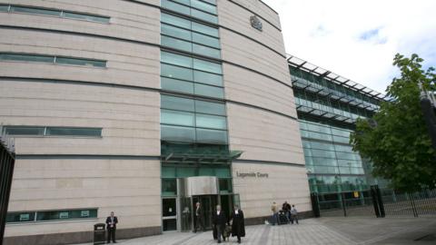 General exterior of Laganside Courts - beige brick and glass windowed tall building 