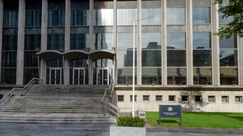 Manchester Crown court. A grey building with rows of steps leading to the entrance.