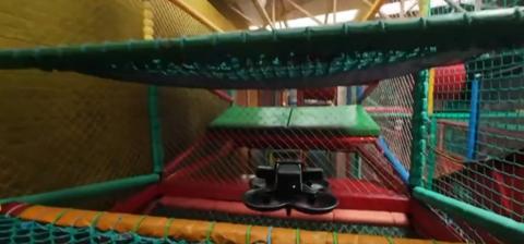 A drone making its way past soft play netting